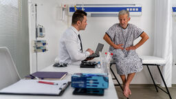 Doctor listens intently to a senior male patient