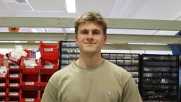 A white man wearing a beige tshirt