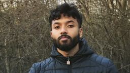 Gaailashwaran stood outside in front of some trees with a warm coat on