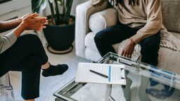Image of two people sitting on sofas in therapy setting