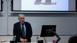 Richard J. Evans in front of screen with text 'conspiracy'