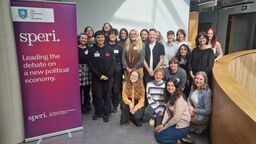 Participants and speakers gather for a photo next to SPERI banner that reads 'Leading the debate on a new political economy'