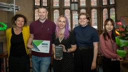 5 members of the School of Law Green Impact team, posing with a certificate, award and a plant. 