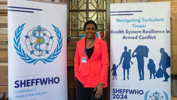 University of Sheffield Africa Scholarship winner Taofeekat Adigun stood between two stand-up banners at an academic conference.