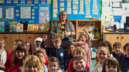 Sabine Little at the front of the classroom with primary aged school children