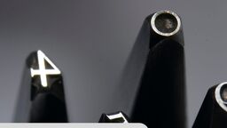 Some silver numbers and symbols against a grey background