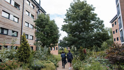 Two students walking in between Endcliffe village accommodation blocks