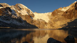 A lake with icy mountains behind it