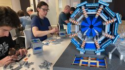 Image of scientists building the LEGO ATLAS detector 