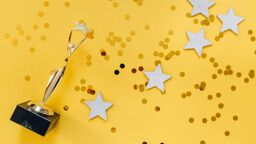 A trophy with gold stars on a yellow background