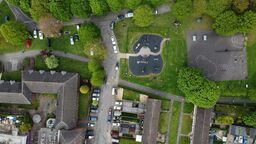 Aerial photograph in the UK featuring houses, cars and a playground