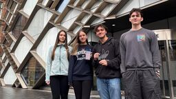 4 students standing outside the Diamond holding their smartwatch device 