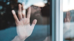 A hand pressed up against a window