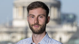 Student Damian Shepherd in front of a blurred building