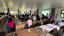 A group of people attend a training session given by Dr Dan Hammett