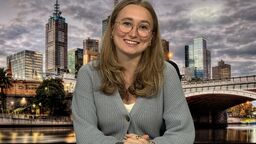 Student Georgia Cook sitting in front of a presenting screen with a city scape