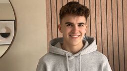 Student Jake Munro-Proud stood in front of a panelled wall