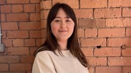 Student with long dark hair smiling in profile image 