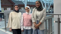 Three students pose for a photograph