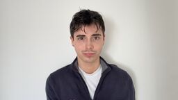 Student with short dark hair and wearing jumper