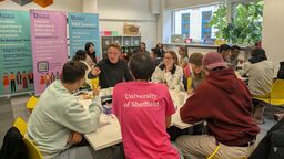 Students and University ambassadors seated around tables playing games and having conversation