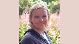 Professor Julie Jones against a background of plants and trees