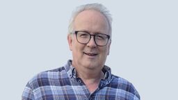 A man in glasses and a blue check pattern shirt 