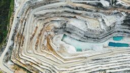 An aerial view of a quarry with a blue pool