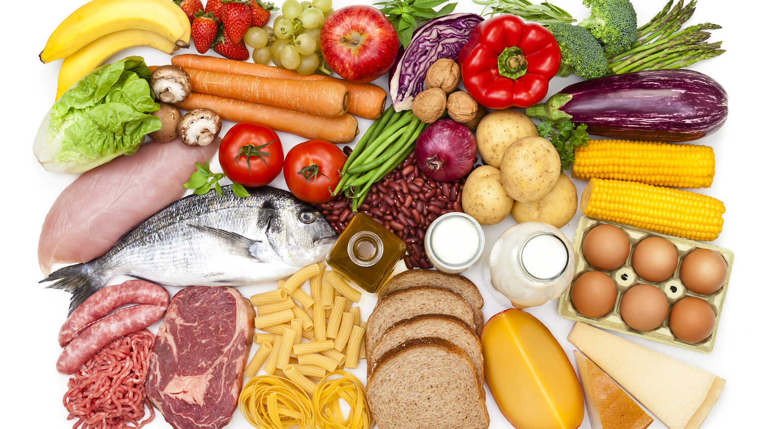 Top view of a white table filled with a large group of different types of food like carbohydrates, protein and dietary fiber. Food included in the composition are dairy products, sausages, minced meat, poultry, fish, bread, pasta, rice, beans, nuts, ol...